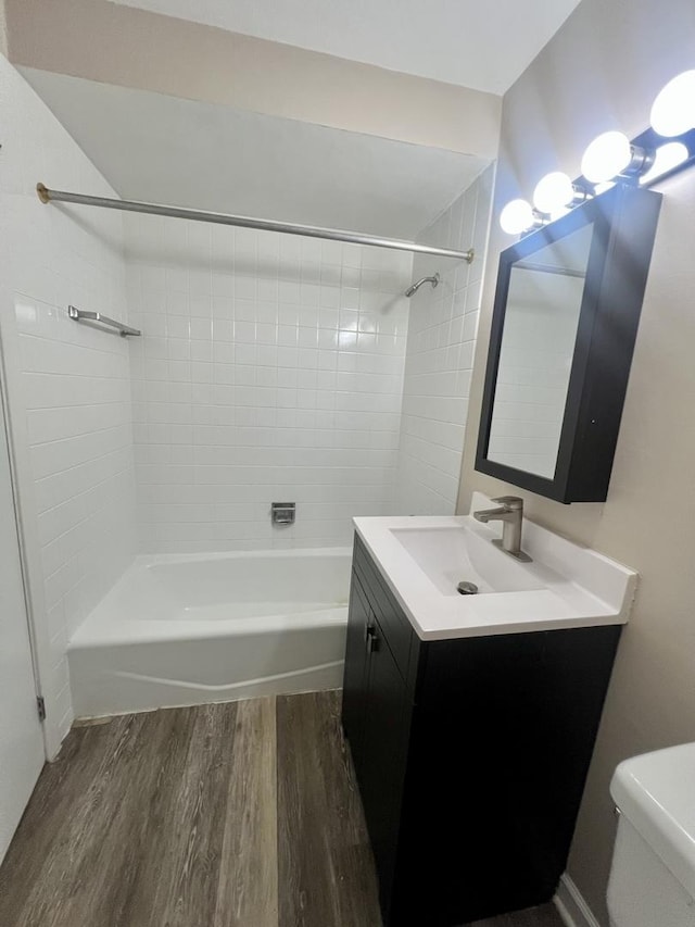 full bathroom featuring wood finished floors, shower / bathtub combination, toilet, and vanity
