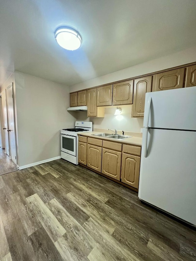 kitchen with white appliances, a sink, dark wood-style floors, and under cabinet range hood