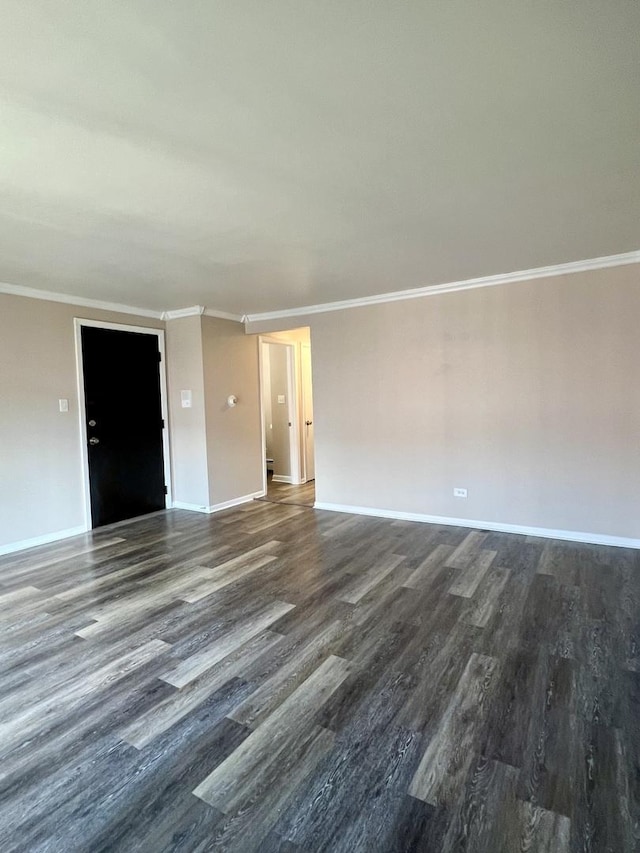 spare room with wood finished floors, ornamental molding, and baseboards