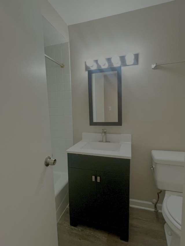 full bathroom featuring toilet, baseboards, vanity, and tub / shower combination