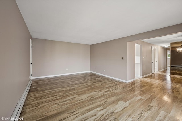 5327 N Delphia Ave Unit 327, Chicago, IL 60656 - empty room featuring wood finished floors, baseboard heating, and a chandelier
