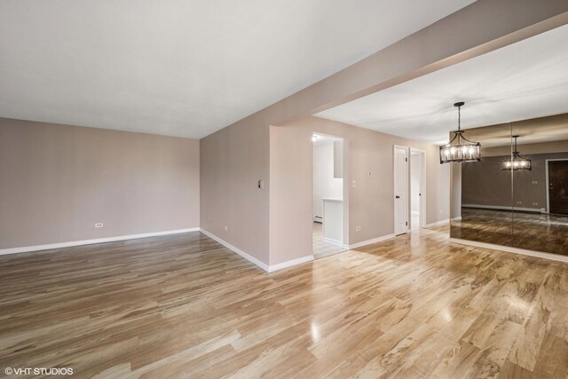 5327 N Delphia Ave Unit 327, Chicago, IL 60656 - unfurnished living room with light wood-style flooring and a chandelier