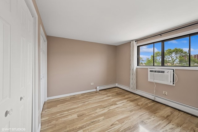 5327 N Delphia Ave Unit 327, Chicago, IL 60656 - unfurnished bedroom featuring light wood finished floors, an AC wall unit, a baseboard radiator, and a closet