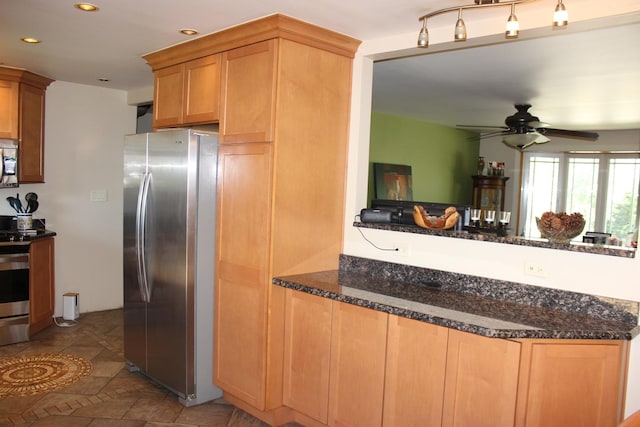 kitchen with stainless steel appliances, a peninsula, recessed lighting, ceiling fan, and dark stone counters