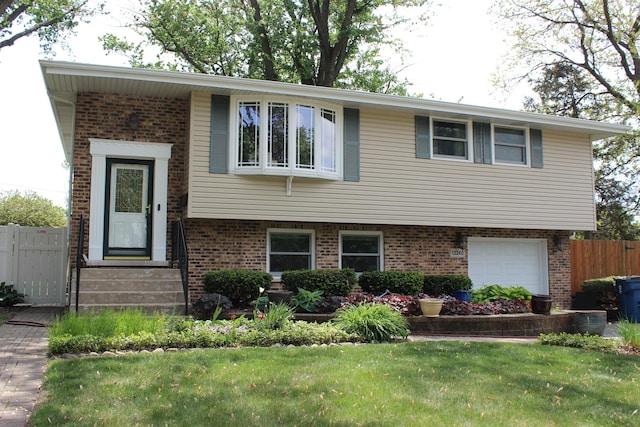 raised ranch featuring brick siding and a garage