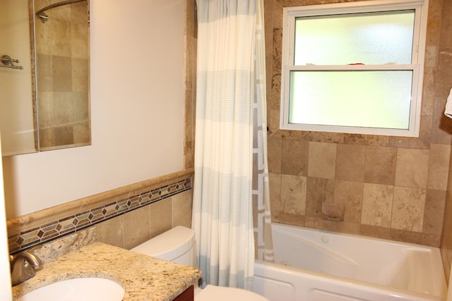 full bathroom featuring tile walls, vanity, shower / bathtub combination with curtain, toilet, and a wainscoted wall