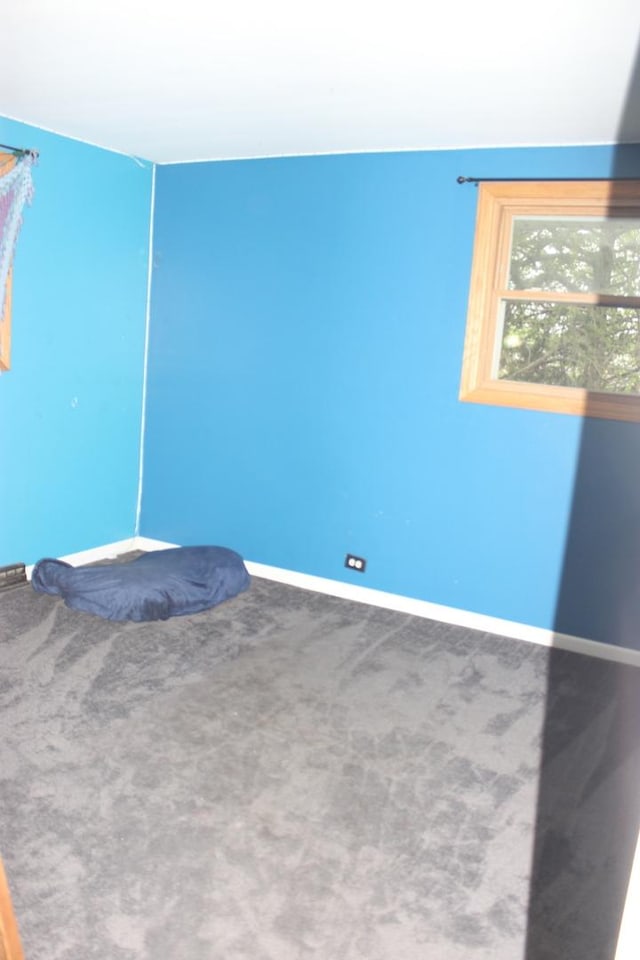 unfurnished bedroom with baseboards and carpet flooring