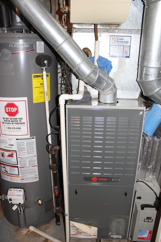 utility room featuring gas water heater and heating unit