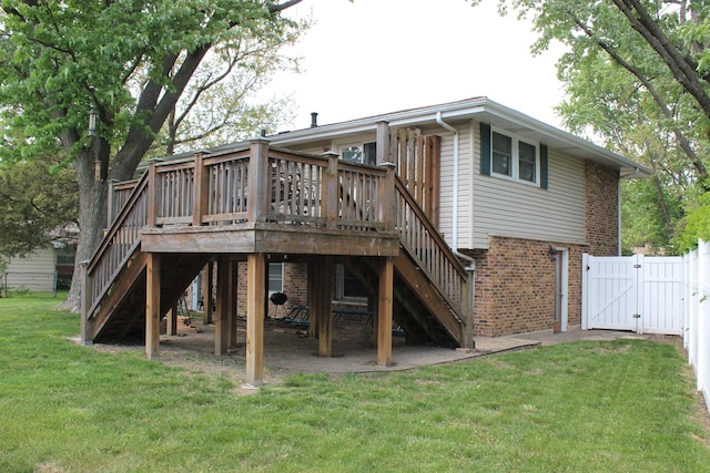 back of property featuring stairs, a gate, brick siding, and a deck
