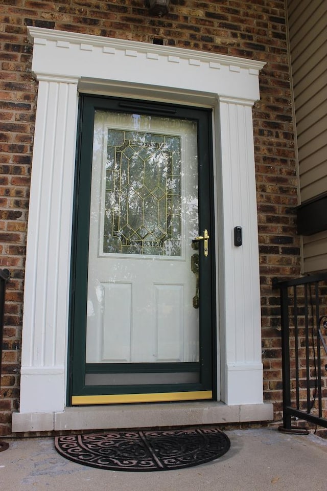 doorway to property with brick siding and board and batten siding