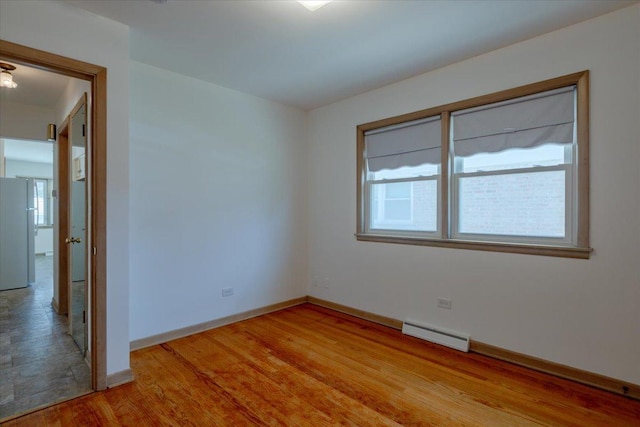 4717 N Newcastle Ave, Harwood Heights, IL 60706 - empty room with baseboards, light wood-style flooring, and a baseboard heating unit