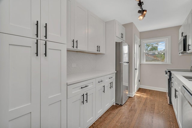 3811 N Pioneer Ave, Chicago, IL 60634 - kitchen featuring stainless steel appliances, baseboards, light countertops, and white cabinetry