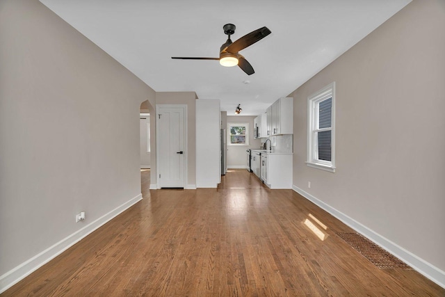 3811 N Pioneer Ave, Chicago, IL 60634 - unfurnished living room with ceiling fan, dark wood finished floors, arched walkways, and baseboards