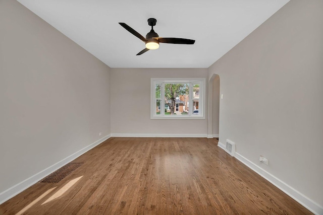 3811 N Pioneer Ave, Chicago, IL 60634 - empty room with wood finished floors, baseboards, ceiling fan, and arched walkways