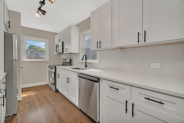 3811 N Pioneer Ave, Chicago, IL 60634 - kitchen with stainless steel appliances, a sink, decorative backsplash, dark wood-style flooring, and white cabinets