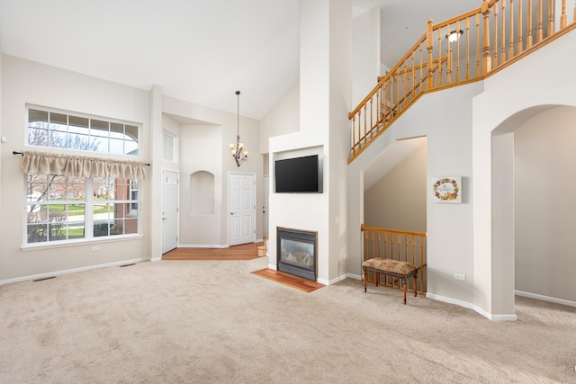 921 Winners Cup Ct, Naperville, IL 60565 - unfurnished living room with carpet flooring, arched walkways, a towering ceiling, and baseboards