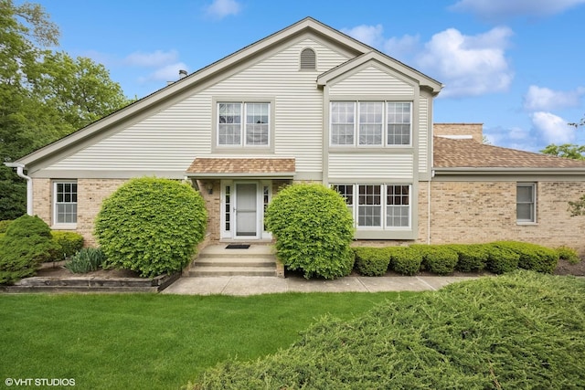 1924 W Ashbury Ln, Inverness, IL 60067 - view of front of house with brick siding, a front lawn, and roof with shingles