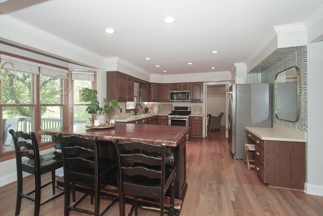 5 Piper Ln, Hawthorn Woods, IL 60047 - kitchen featuring stainless steel appliances, a sink, a peninsula, crown molding, and wood finished floors