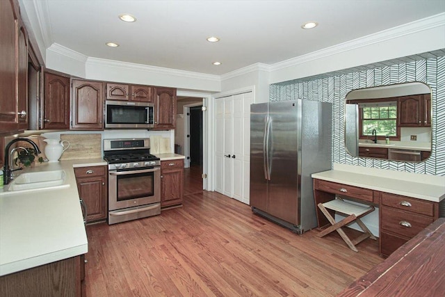 5 Piper Ln, Hawthorn Woods, IL 60047 - kitchen featuring appliances with stainless steel finishes, a sink, ornamental molding, light wood-style flooring, and light countertops
