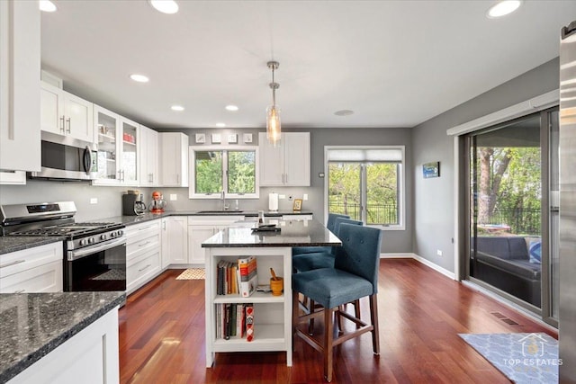 203 Royal Ct, Prospect Heights, IL 60070 - kitchen featuring stainless steel appliances, a kitchen bar, dark wood-style floors, dark stone counters, and recessed lighting