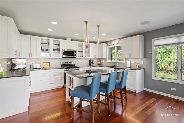 203 Royal Ct, Prospect Heights, IL 60070 - kitchen featuring stainless steel appliances, white cabinets, dark wood-style flooring, glass insert cabinets, and a center island