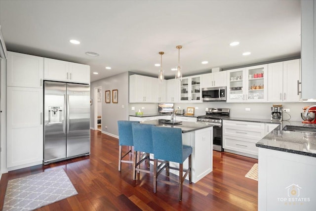 203 Royal Ct, Prospect Heights, IL 60070 - kitchen featuring appliances with stainless steel finishes, a sink, dark wood-type flooring, a kitchen bar, and glass insert cabinets