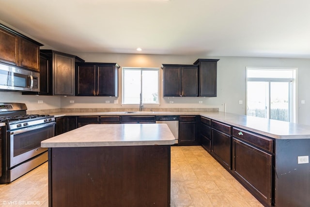 433 Minuet Cir, Volo, IL 60073 - kitchen with appliances with stainless steel finishes, a sink, light countertops, a peninsula, and dark brown cabinets