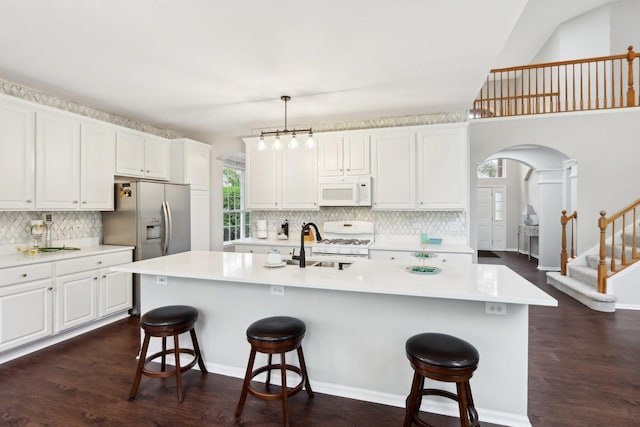 2913 Glenarye Dr, Lindenhurst, IL 60046 - kitchen with white appliances, a sink, a kitchen bar, backsplash, and dark wood-style floors
