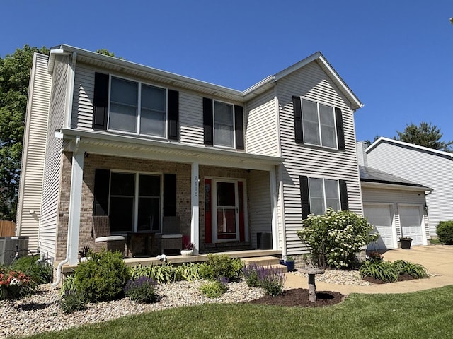 2610 Worthington Dr, Champaign, IL 61822 - traditional home featuring covered porch, driveway, an attached garage, cooling unit, and brick siding