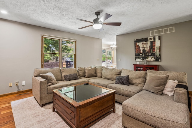 2610 Worthington Dr, Champaign, IL 61822 - living area featuring a textured ceiling, ceiling fan, plenty of natural light, light wood-style flooring, and a chandelier