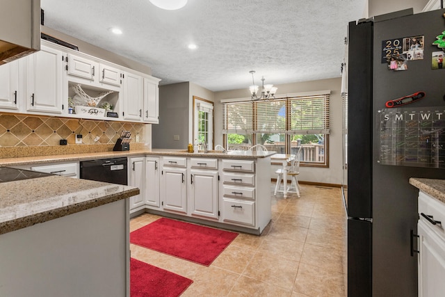 2610 Worthington Dr, Champaign, IL 61822 - kitchen featuring freestanding refrigerator, a peninsula, backsplash, white cabinetry, and a chandelier