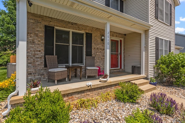 2610 Worthington Dr, Champaign, IL 61822 - view of exterior entry with covered porch, brick siding, and central air condition unit