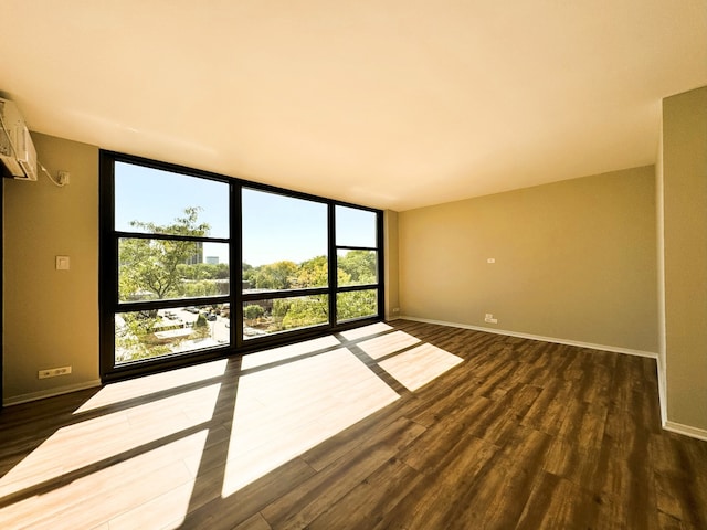 2605 S Indiana Ave Unit 501, Chicago, IL 60616 - unfurnished room featuring expansive windows, baseboards, dark wood-type flooring, and a wall mounted air conditioner