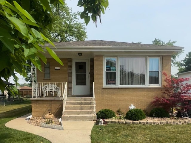 3434 Monroe St, Lansing, IL 60438 - view of front facade featuring brick siding, covered porch, and a front lawn