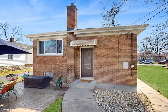 3434 Monroe St, Lansing, IL 60438 - view of front of home featuring brick siding, a patio area, a front lawn, and a chimney