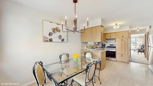 3434 Monroe St, Lansing, IL 60438 - kitchen with appliances with stainless steel finishes, light brown cabinets, under cabinet range hood, a chandelier, and a sink