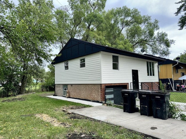 13235 S Vernon Ave, Chicago, IL 60827 - view of home's exterior featuring brick siding, concrete driveway, a garage, and board and batten siding