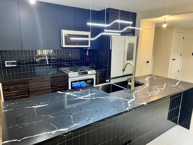 13235 S Vernon Ave, Chicago, IL 60827 - kitchen with stainless steel range with gas stovetop, white refrigerator, decorative backsplash, dark stone countertops, and blue cabinets