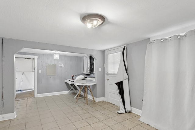 3731 Maple Ave, Berwyn, IL 60402 - dining room with baseboards, light tile patterned flooring, and arched walkways