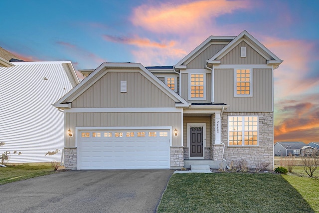 craftsman house featuring stone siding, asphalt driveway, a garage, and a lawn