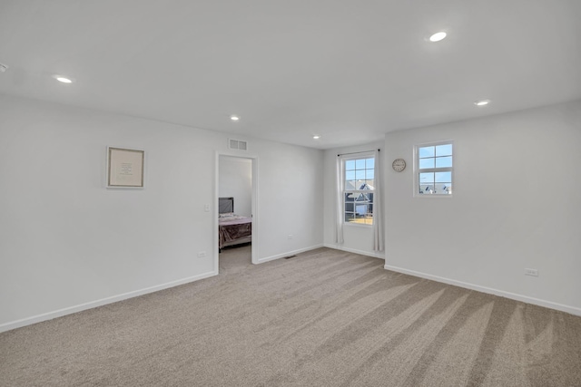 carpeted empty room featuring recessed lighting and baseboards