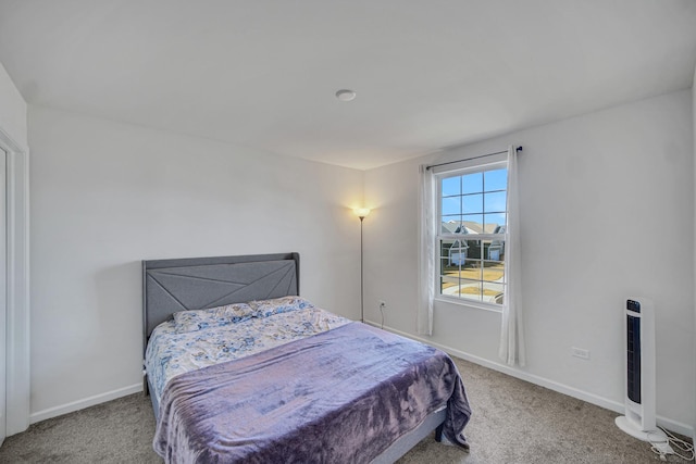 carpeted bedroom featuring baseboards and heating unit