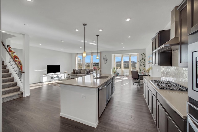 kitchen with a sink, appliances with stainless steel finishes, open floor plan, dark brown cabinetry, and recessed lighting