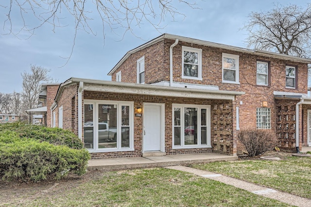 view of front of property featuring brick siding and a front yard