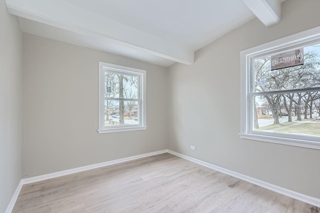 empty room featuring beamed ceiling, light wood-type flooring, and baseboards