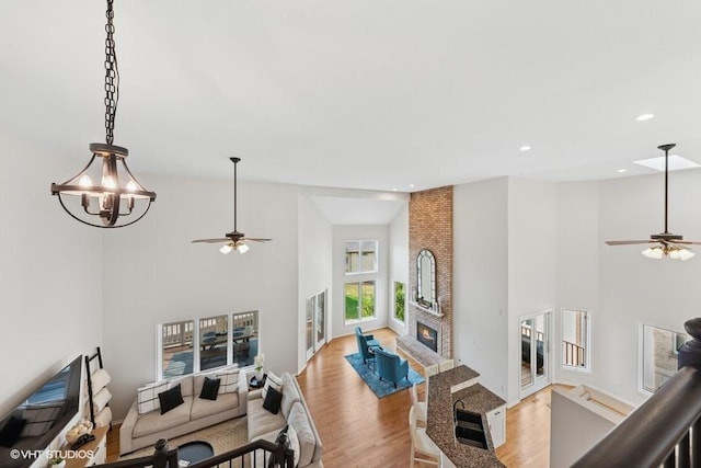 21827 W Riviera Ct, Ivanhoe, IL 60060 - living room with ceiling fan, a high ceiling, light wood-style floors, recessed lighting, and a fireplace