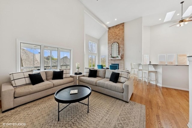 21827 W Riviera Ct, Ivanhoe, IL 60060 - living room featuring high vaulted ceiling, wood finished floors, a skylight, healthy amount of natural light, and baseboards