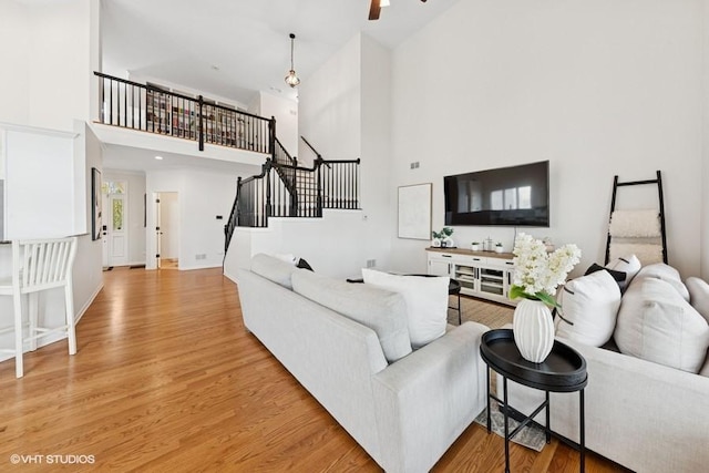 21827 W Riviera Ct, Ivanhoe, IL 60060 - living area featuring a high ceiling, light wood finished floors, stairs, a ceiling fan, and baseboards