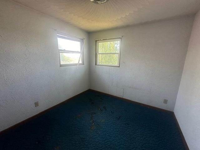 empty room featuring dark carpet