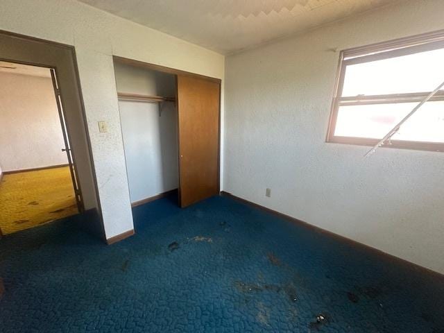 112 Minton St, Joliet, IL 60436 - unfurnished bedroom featuring dark carpet, a closet, and baseboards